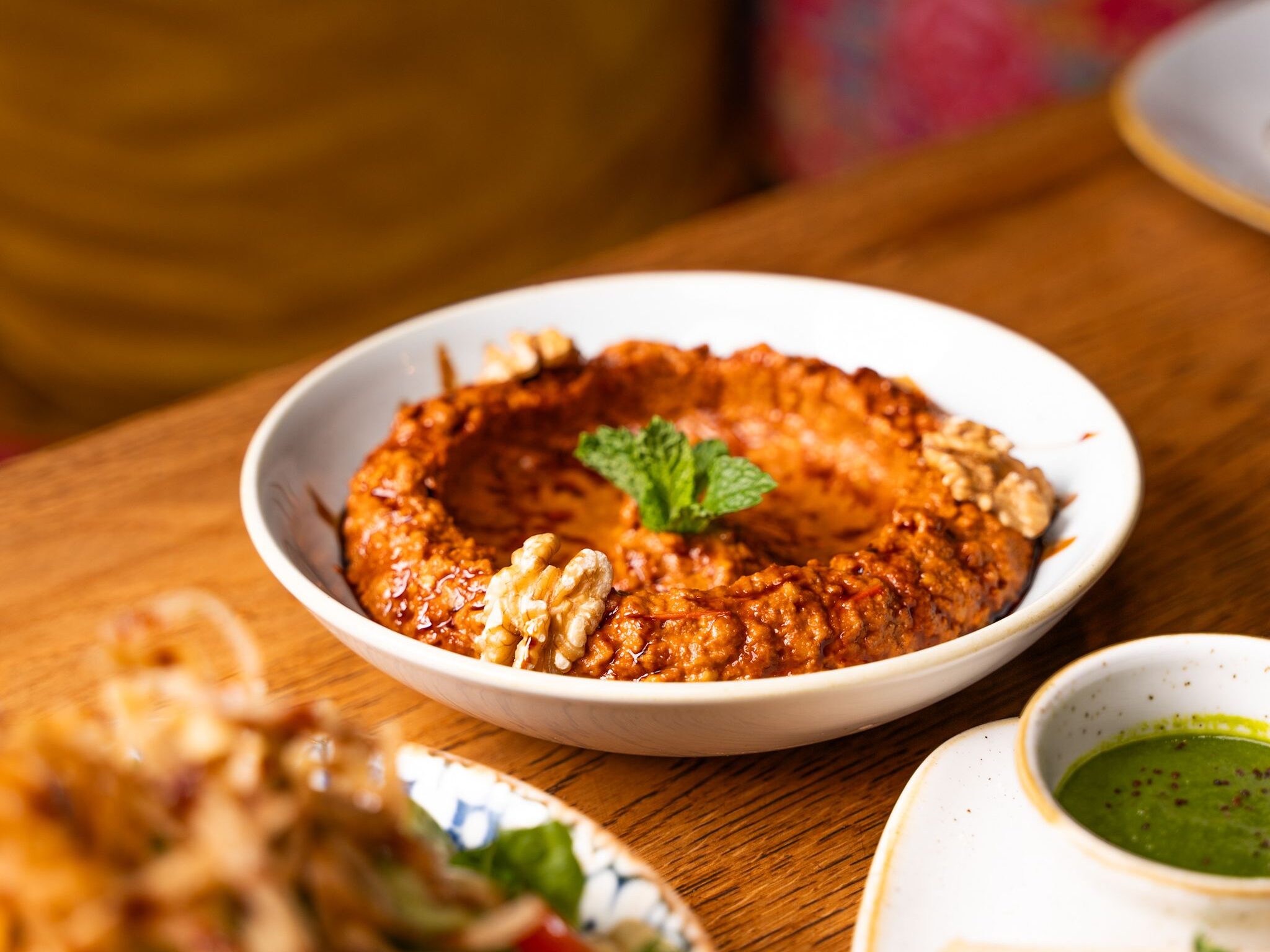 High-angle close-up of Mediterranean dishes featuring flavorful muhammara dip with walnuts.